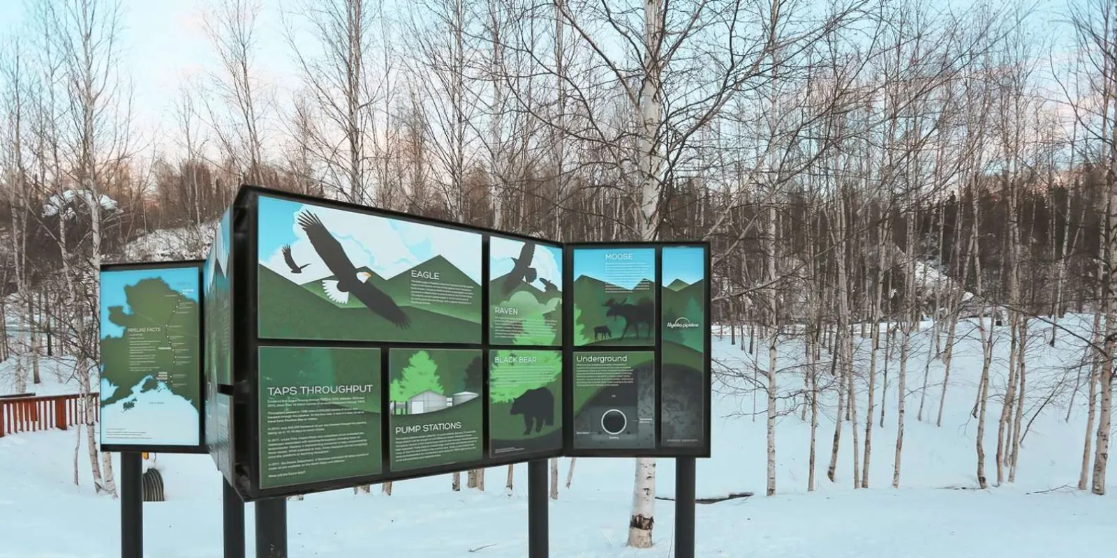 Informational signboards about eagles, moose, and the Trans-Alaska Pipeline at a highway stop