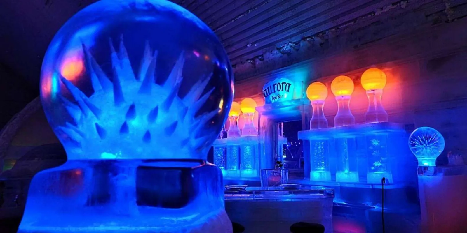 Glowing blue and orange hand-carved ice sculptures at the Aurora Ice Museum's ice bar