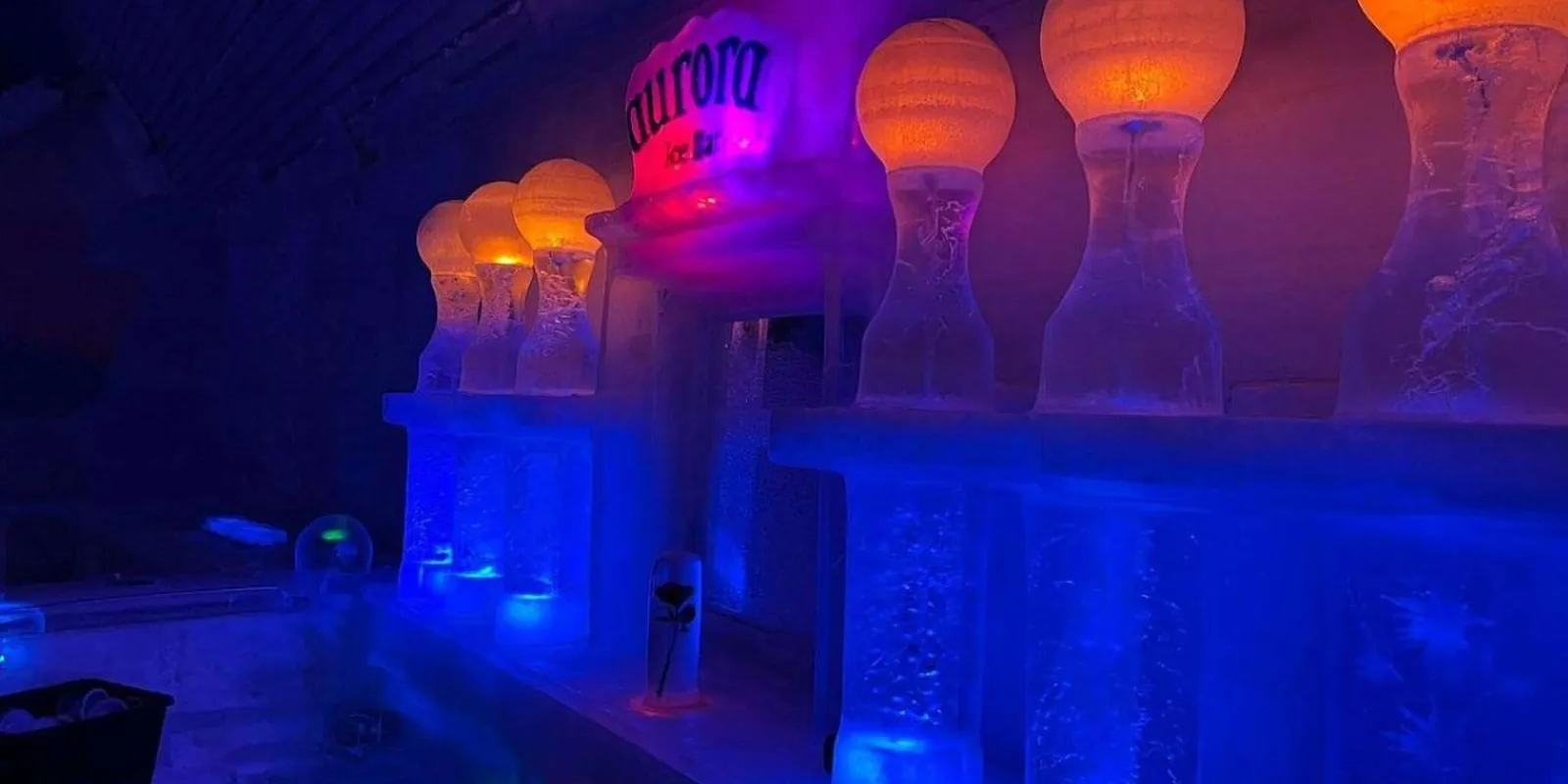 Glowing blue and orange ice sculptures inside the Aurora Ice Museum's ice bar