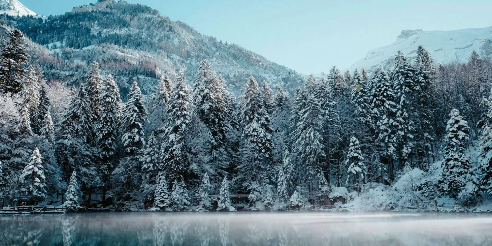 Snow-covered mountains and forest reflected in a still lake near Chena Hot Springs