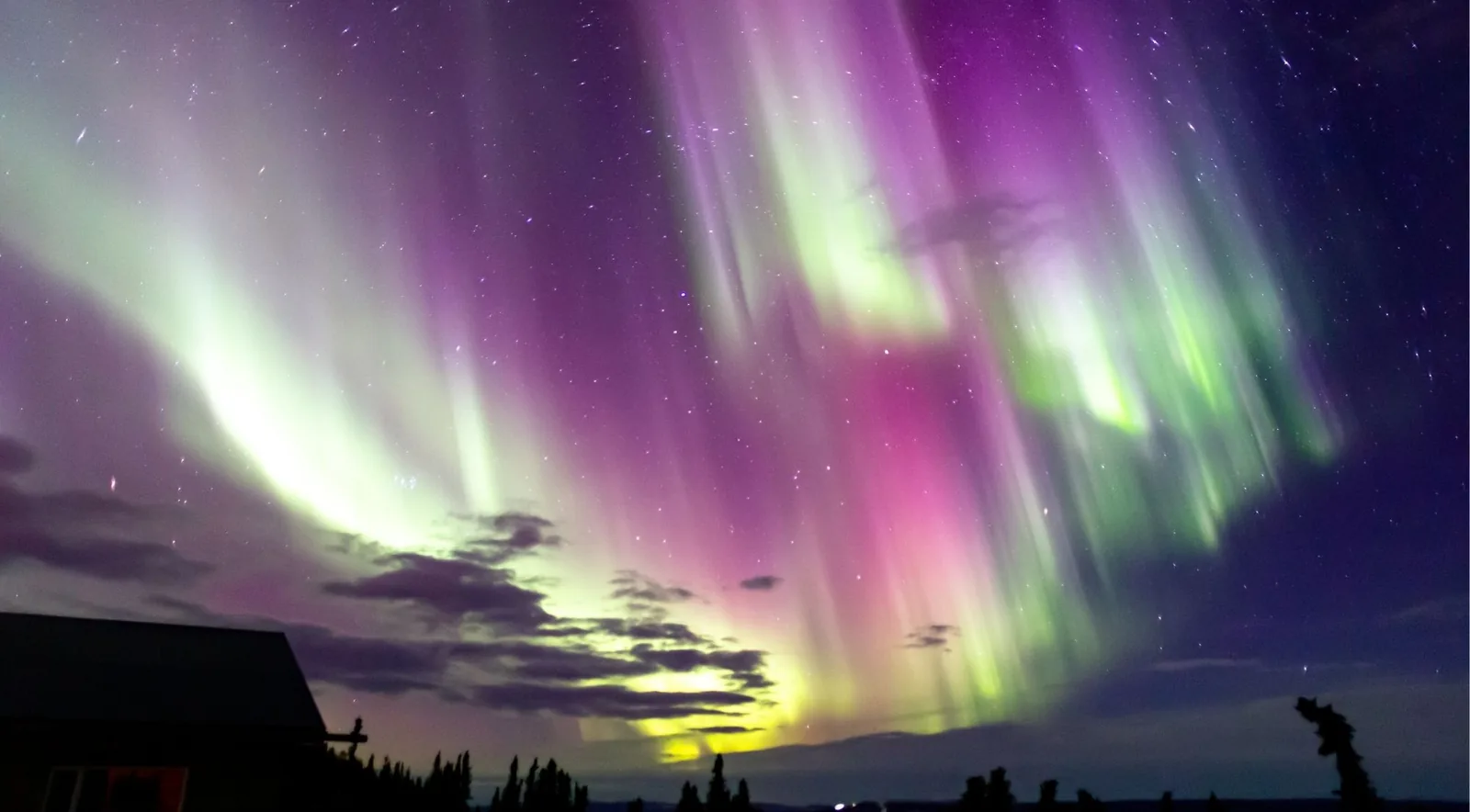Magenta and green aurora over a Fairbanks-area cabin, the kind of display an evening tour chases after your museum visit